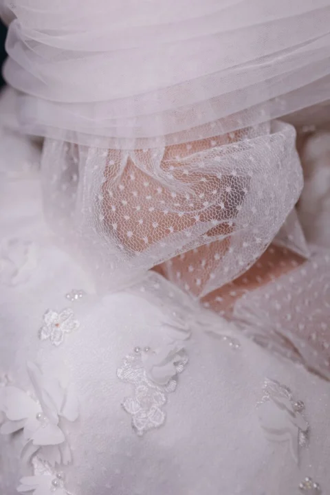 White sheer fabric with small dots and embroidered flowers.