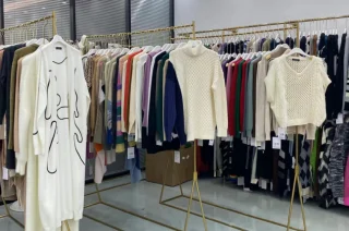 Sweaters and knit vests on garment racks.