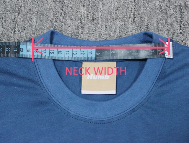 A tape measure laid across the neck opening of a blue crew-neck T-shirt.