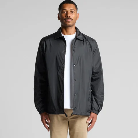 A man in a black coach jacket with a pointed collar and snap front.