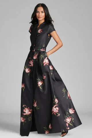 A black floral gown with a shirt-style bodice, a belt and a full skirt to the floor.