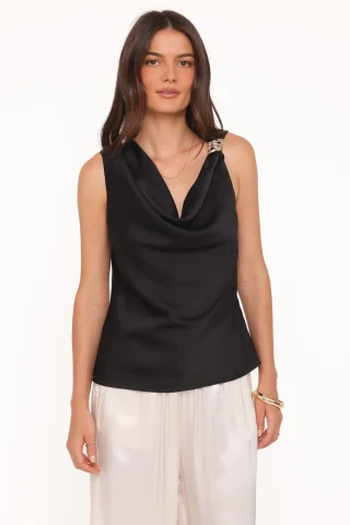 A black satin cowl-neck blouse with gold hardware at one shoulder and a loose fold across the chest.