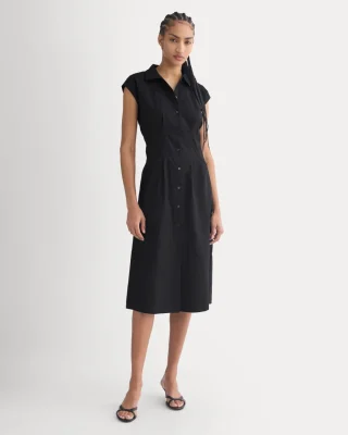 A black sleeveless cotton shirt dress with a button front and a midi skirt.