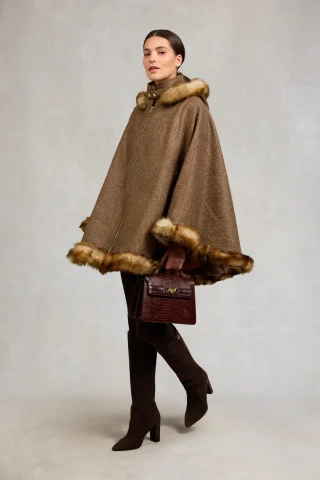 A brown herringbone cape with a shearling-style trim, worn with tall brown boots.