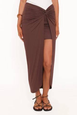 A brown sarong-style skirt with a fixed twist at the front waist and long diagonal folds.