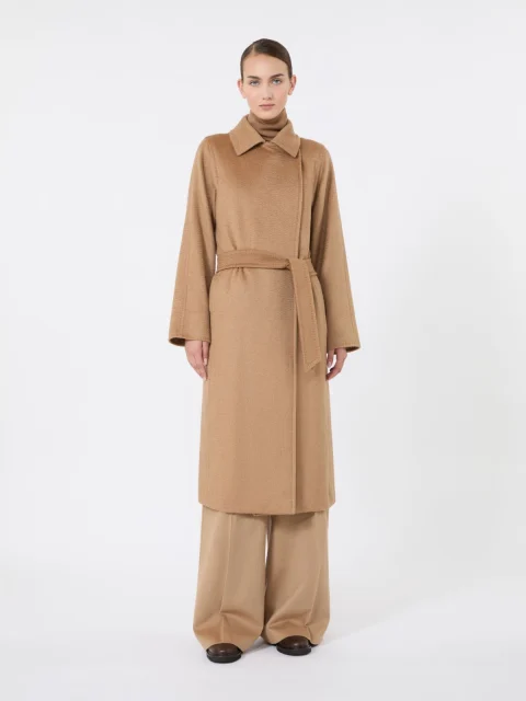 A camel wrap coat tied at the waist, worn over matching wide-leg trousers.