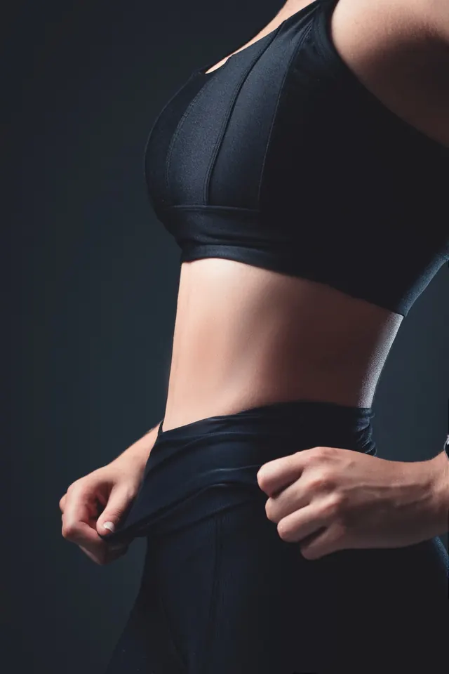 Close-up of a black sports bra and the waistband of black high-rise leggings.