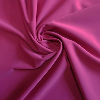 Magenta stretch swim fabric gathered into a swirl.