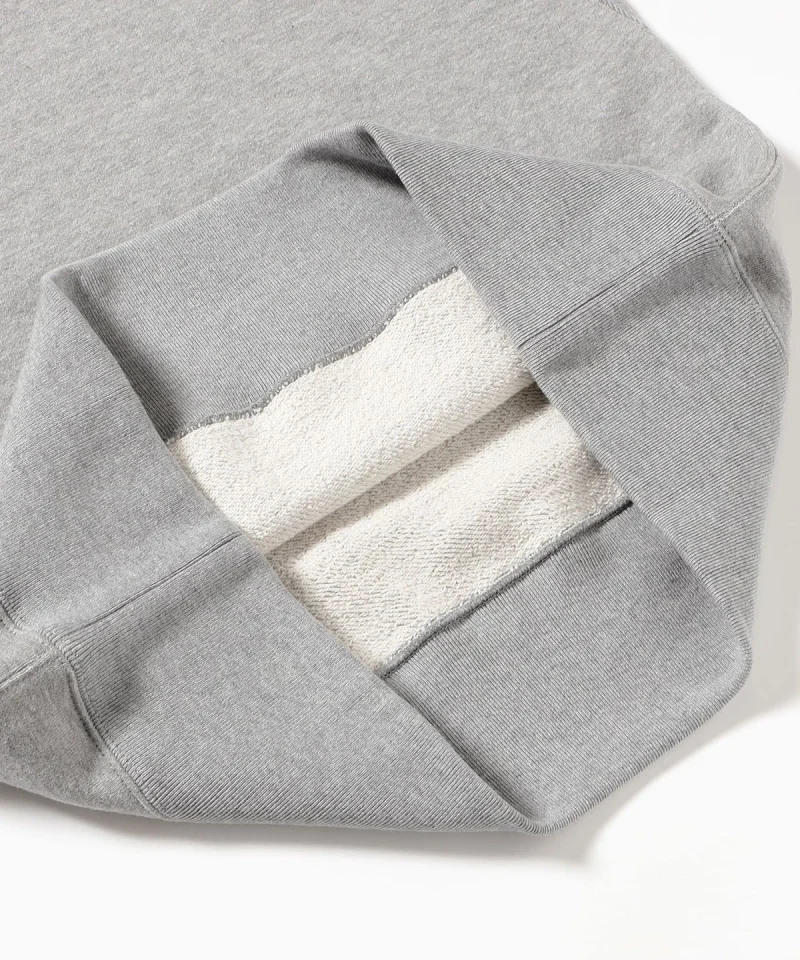 A gray French terry sweatshirt turned back at the hem to show the looped inside.