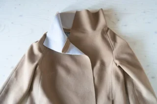 An unfinished camel coat with its interfacing showing.