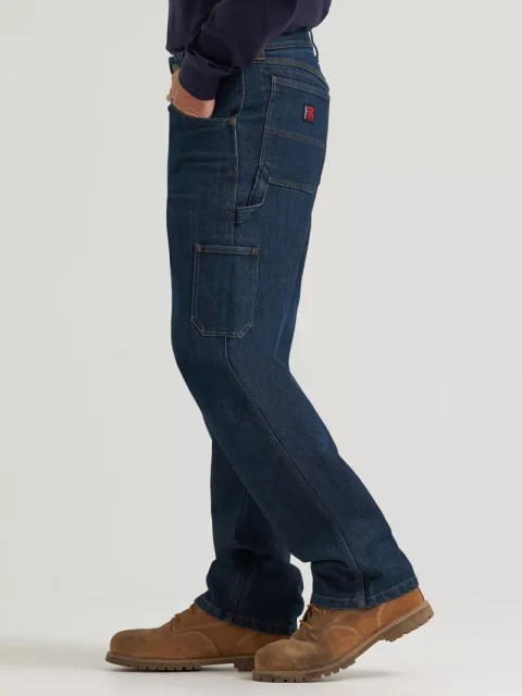 A man in dark carpenter jeans with side utility pockets and brown work boots.