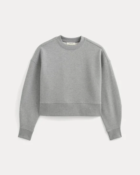 A heather gray cropped crewneck sweatshirt with full-length sleeves.