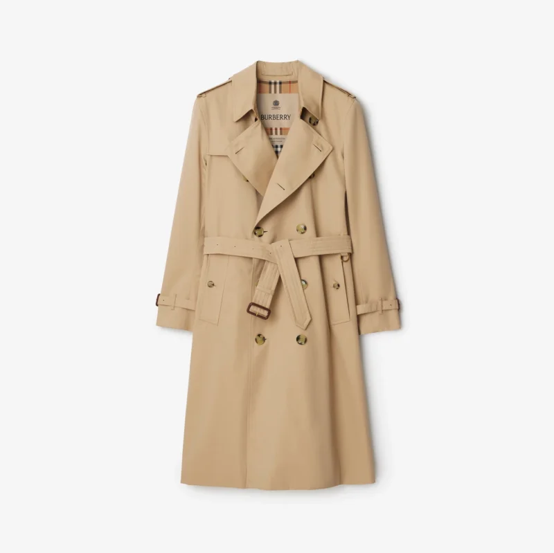 A honey-beige trench coat with broad lapels, a belt, shoulder straps and buckled cuffs.