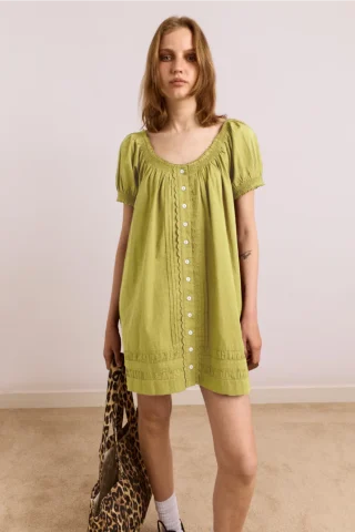A loose celery-green cotton smock mini dress with puff sleeves and a button front.