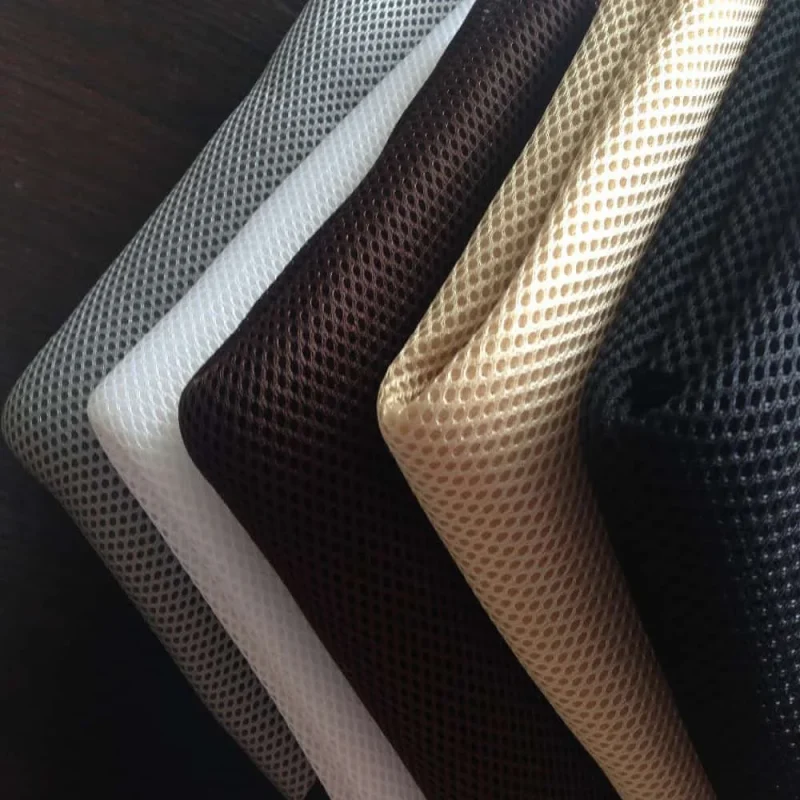 Polyester mesh in white, beige, brown and black, fanned out in layers.