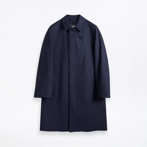 A navy mac coat with a small collar and a concealed single-breasted front.