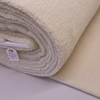A roll of oatmeal sherpa fleece showing the pile across a wide cutting.