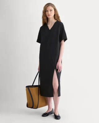 An oversized black V-neck T-shirt midi dress with elbow-length sleeves and a front slit.