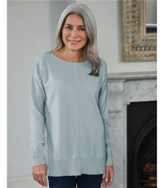 A woman in a long pale blue sweater with a wide, shallow boat neckline.