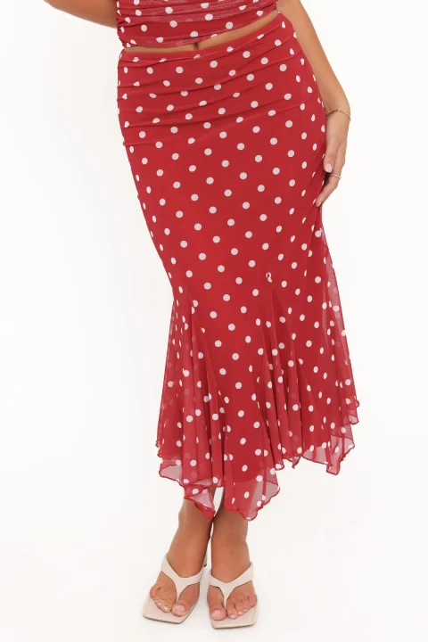 A red polka-dot skirt with a fitted upper section and a handkerchief hem of sheer pointed tips.