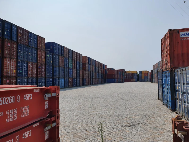 Rows of shipping containers stacked at a port depot.