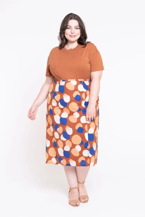 A straight midi skirt with orange, blue and cream spots, worn with a tucked orange T-shirt.