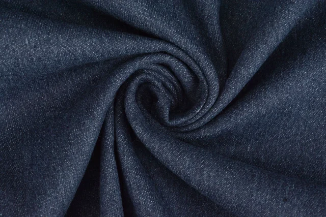 Dark blue stretch denim twisted into a swirl.