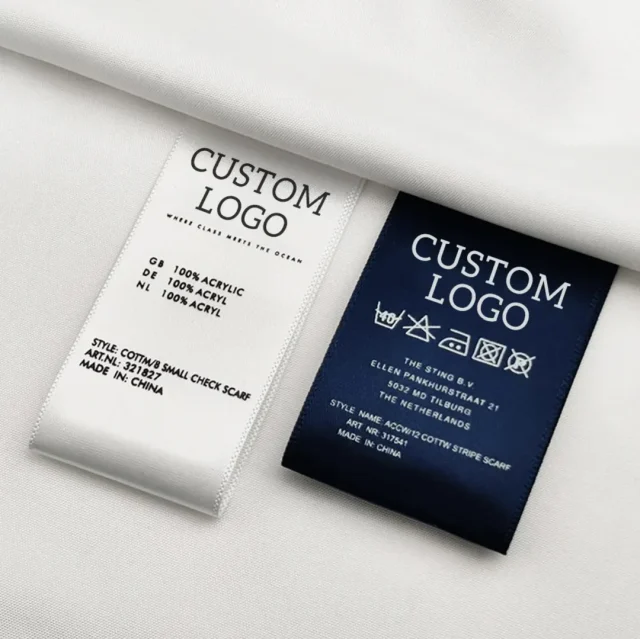 A white and a navy woven label printed with a placeholder logo, fiber content, care symbols and the country of origin.