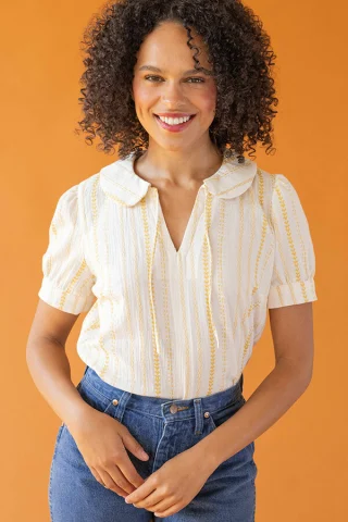 A white and yellow striped blouse with a flat rounded collar, neck ties and short gathered sleeves.