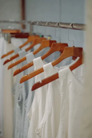 White blouses on wooden hangers.