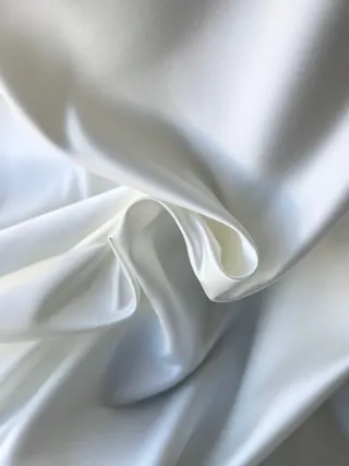 White satin gathered into soft, structured folds.