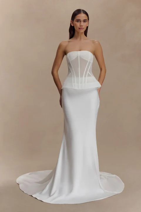 A white mermaid maxi skirt fitted through the hips and flaring into a back train.