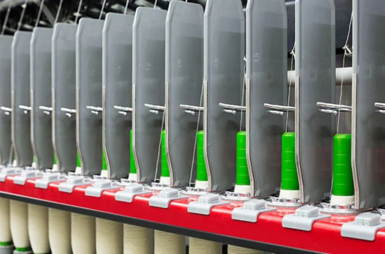 Yarn bobbins along a ring-spinning frame.