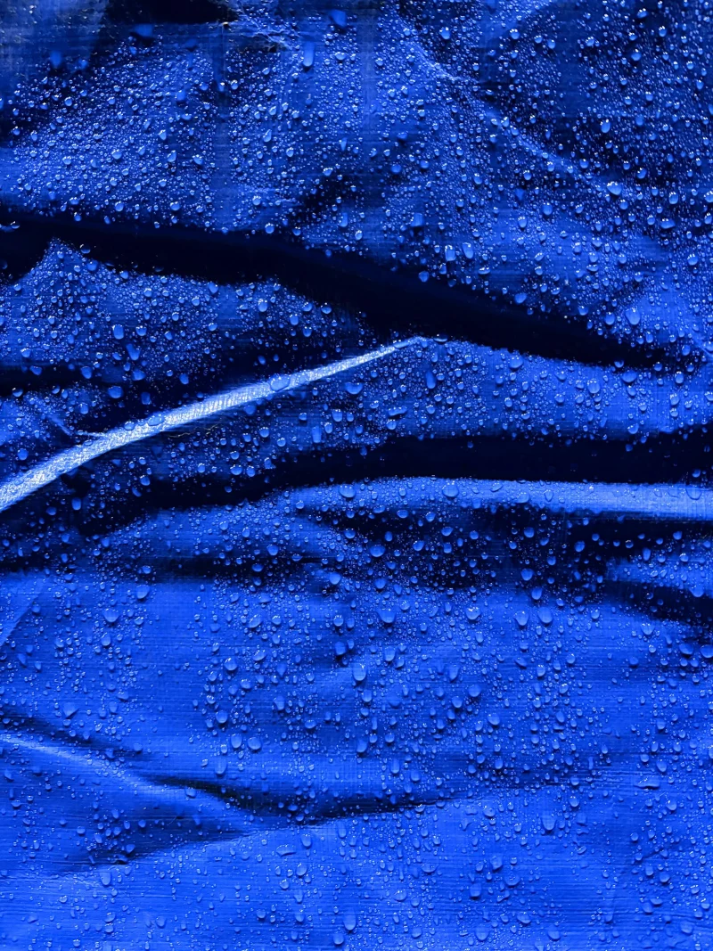 Water drops beading on a blue fabric.