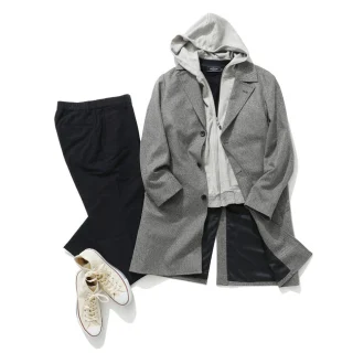 A grey coat laid flat with a hoodie, trousers and sneakers on a white background.