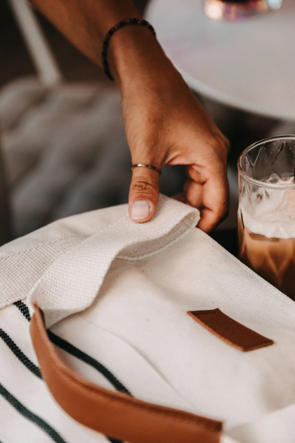 A natural canvas tote with a leather handle and a leather patch.