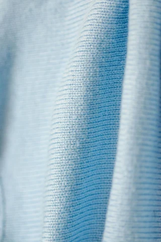 Close view of a light blue cotton knit falling in soft folds.