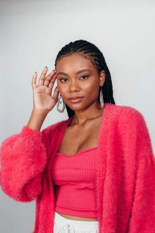 Woman in a fluffy hot-pink cardigan over a pink ribbed top.