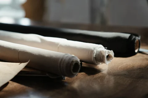 Rolls of cotton canvas on a workshop table.