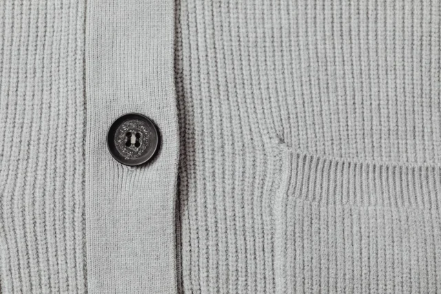Grey ribbed cardigan front with one dark button.